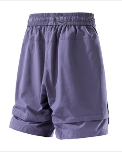 Dettaglio macro dei pantaloncini sportivi viola che mostra la trama e l'orlo a strati