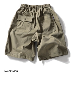 Detail of cargo shorts back pockets and elastic waistband in olive green cotton fabric