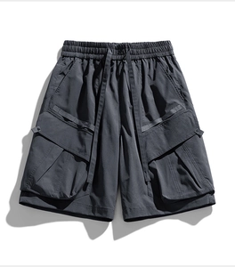 Detail of dark grey cargo shorts with elastic drawstring waist and tactical side pockets