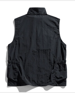 Detailed back view of a black tactical vest showing rugged fabric and large cargo pockets
