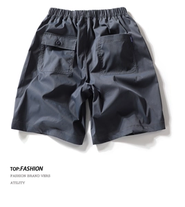 Detail view of cargo shorts back pockets with elastic drawstring waist and blue woven labels