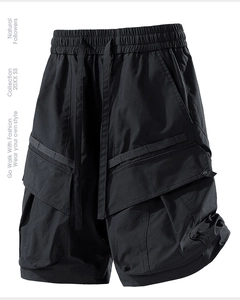 Detail view of black utility cargo shorts featuring 3D pockets and elastic drawstring waist