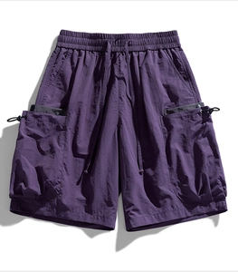 Detail of dark purple cargo shorts featuring drawstring waist and functional 3D pockets
