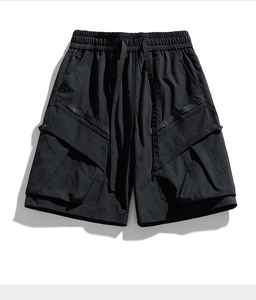 Detail of black techwear cargo shorts with elastic drawstring waist and 3D utility pockets