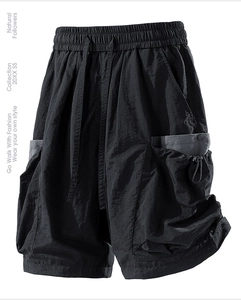 Detail of black technical cargo shorts with drawstring elastic waist and side pockets