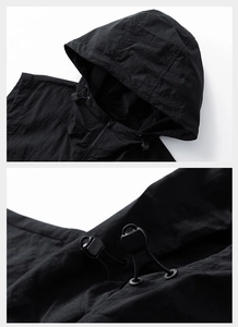 Détail du gilet outdoor noir à capuche avec cordon de serrage et texture du tissu