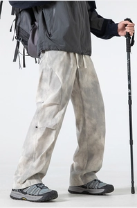 Detail of gray tie-dye cargo pants with drawstring waist and articulated knees design