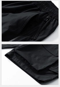 Dettagli dei pantaloncini cargo neri con elastico in vita, tasca con zip e patta utility