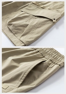 Detailed macro view of khaki cargo shorts showing reinforced pockets and elastic waistband
