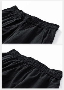 Detail view of high elastic waistband and adjustable drawstring on black cargo shorts