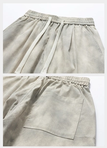 Detailed close-up of drawstring elastic waist and back pocket on tie-dye twill trousers