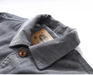 Detail view of corduroy jacket collar with resin button and brown leather brand label