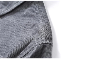 Detailed macro shot of gray corduroy fabric texture and shoulder stitching on jacket