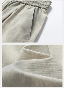 Detail of elastic drawstring waistband and twill fabric texture on light khaki trousers