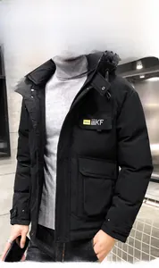 Close-up of black hooded parka with utility pockets and yellow chest logo detail