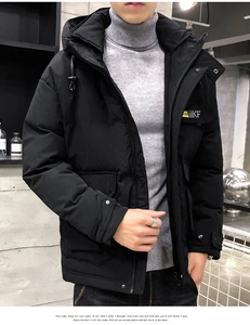 Detail of men's black hooded winter jacket with industrial brand badge and metal snap cuffs