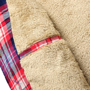 Detail of warm brown sherpa lining and interior pocket on a plaid flannel jacket