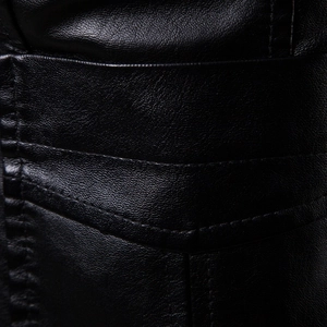 Detailed macro view of black pebble-grain faux leather jacket with neat contrast stitching