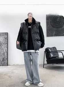 Full view of men's black leather puffer vest paired with grey wide-leg jeans in street style
