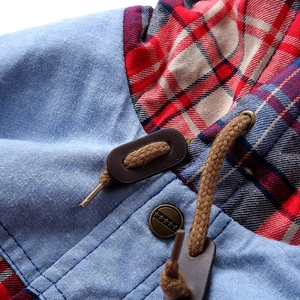 Detail of hooded denim shirt featuring plaid lining and stars engraved metal button