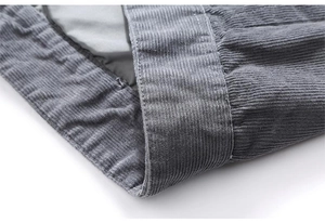Detailed macro view of dark grey corduroy fabric with precise stitching and inner lining