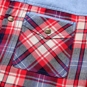Detail of red-blue plaid fabric with denim trim and gold star metal button on pocket