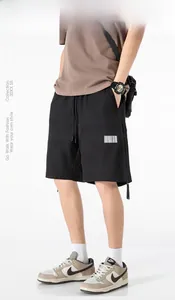 Detail of black drawstring waist shorts with barcode style patch and street style cargo fit