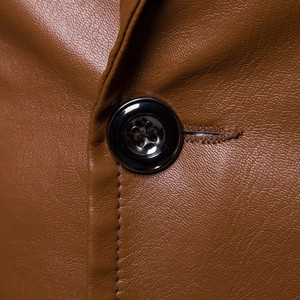 Detail of dark brown faux leather jacket with fine grain texture and polished button