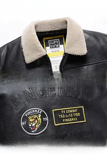 Detail of black PU leather jacket featuring faux shearling collar and tiger head embroidery