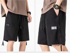 Detail of black cargo shorts featuring elastic waistband and tactical barcode print