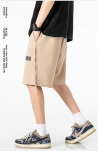 Detail view of khaki casual shorts featuring a vertical side zipper and barcode print