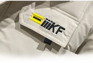 Close-up of chest pocket with iiikF embroidery and yellow contrast on beige puffer jacket