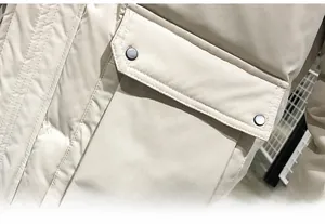 Detail of beige puffer jacket showing oversized cargo pocket with silver metal snap button