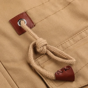 Detail of drawstring on khaki hooded jacket with leather reinforcements and metal eyelets