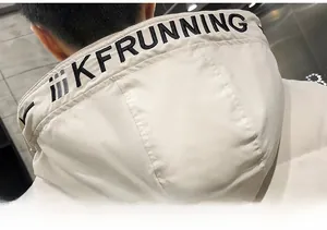 Detail view of beige men's jacket hood featuring bold black KFRUNNING letter embroidery
