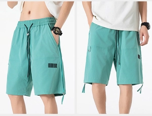 Close-up of mint green casual shorts featuring an elastic drawstring and side zip detail