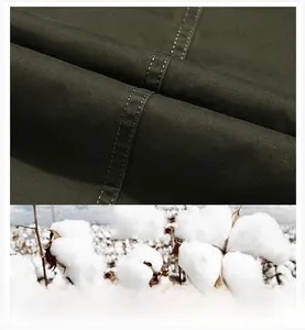 Detailed macro view of olive green cotton twill fabric with premium double-stitch seam