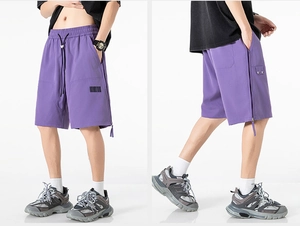 Detail view of purple quick-dry shorts with drawstring waist and side zipper elements