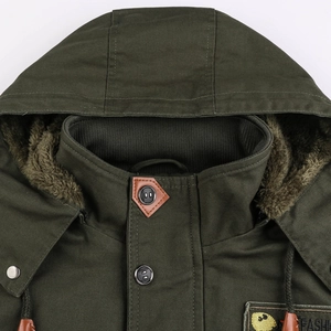 Detail of army green canvas jacket featuring plush lining and button closure with leather trim