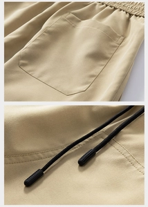 Detail view of khaki casual shorts featuring an elastic waistband and black drawstring texture