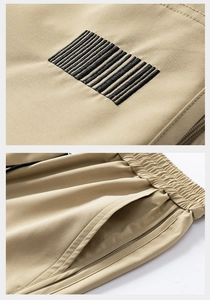 Detail of khaki tech shorts featuring elastic waistband and barcode embroidery