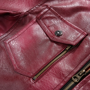 Close-up of burgundy leather motorcycle jacket with metal zipper and snap button pockets