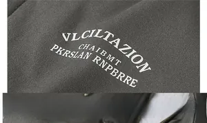 Macro detail of dark grey jacket fabric with white VLCILTAZION graphic lettering print