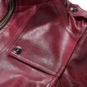 Detailed macro view of dark red PU leather texture with fine stitching and metal snap buttons