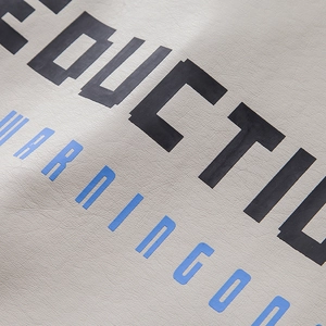 Close-up of high-quality faux leather jacket fabric with precise printed text details