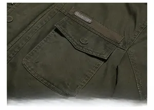 Detailed close-up of military green cargo jacket chest pocket with vintage metal button