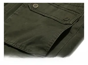 Detail of military style green cotton jacket showing flap pocket and metal buckle