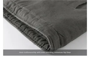 Detailed close-up of heavy-duty double-stitched hem on a dark green winter jacket