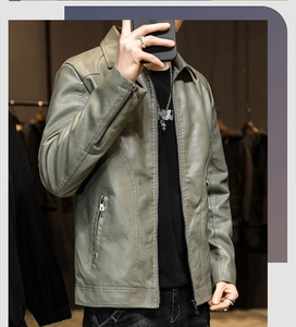 Detail of slim fit green PU leather jacket with metallic zippers and stand collar