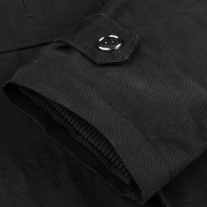 Detailed macro view of black military jacket cuff with rib knit and adjustable button strap